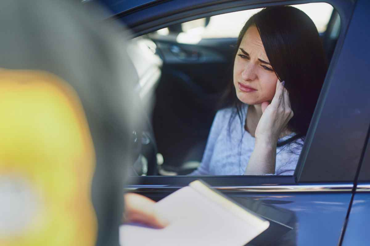 donna con mano in testa e multa La multa da 50 euro che diventano 2800, ecco i dettagli